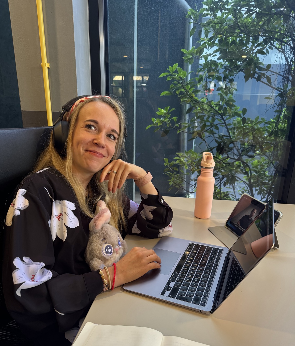 Sanne met koptelefoon achter haar laptop, aan het studeren