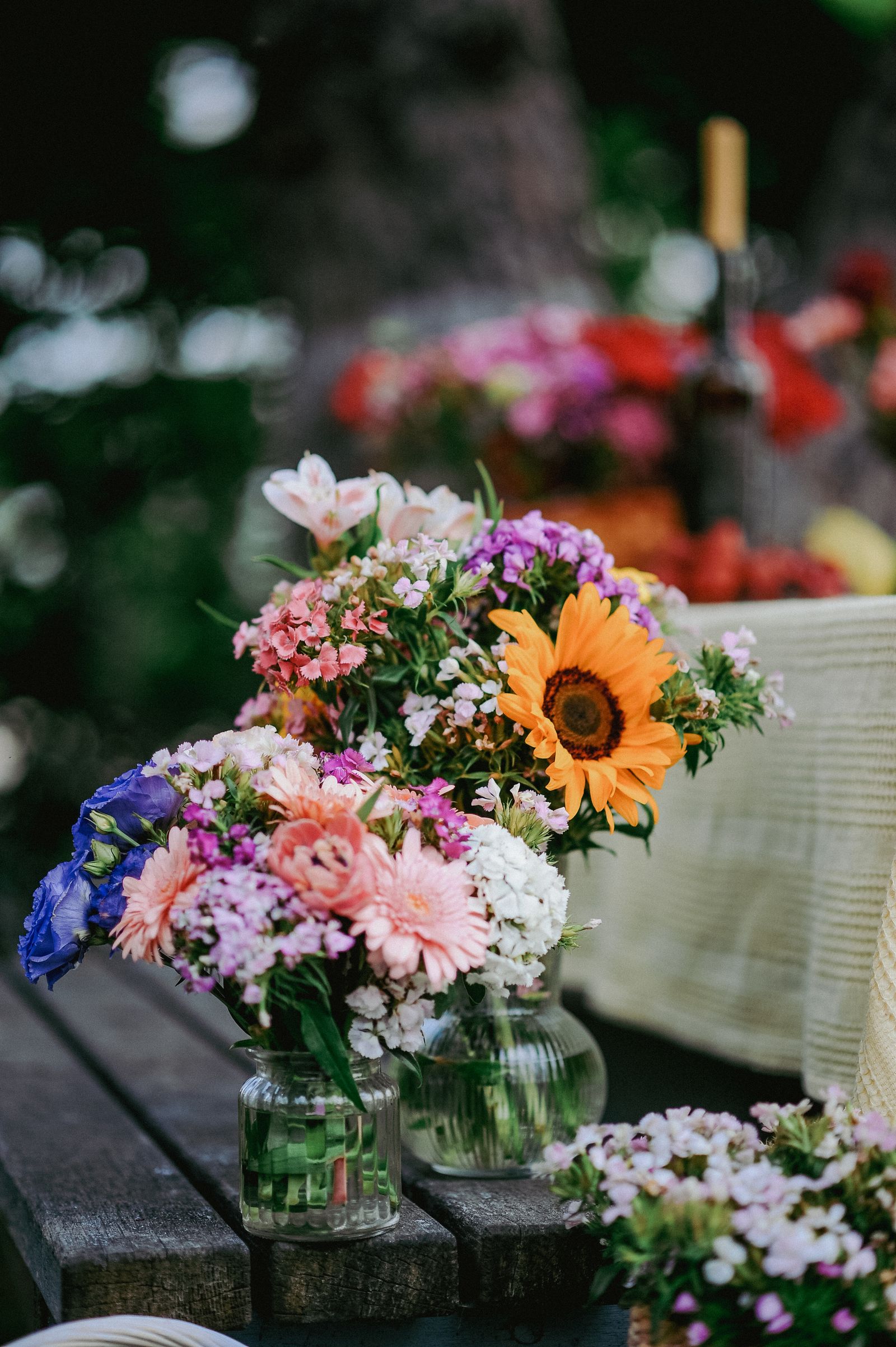 Vaasjes met kleurige bloemen op een houten tafel