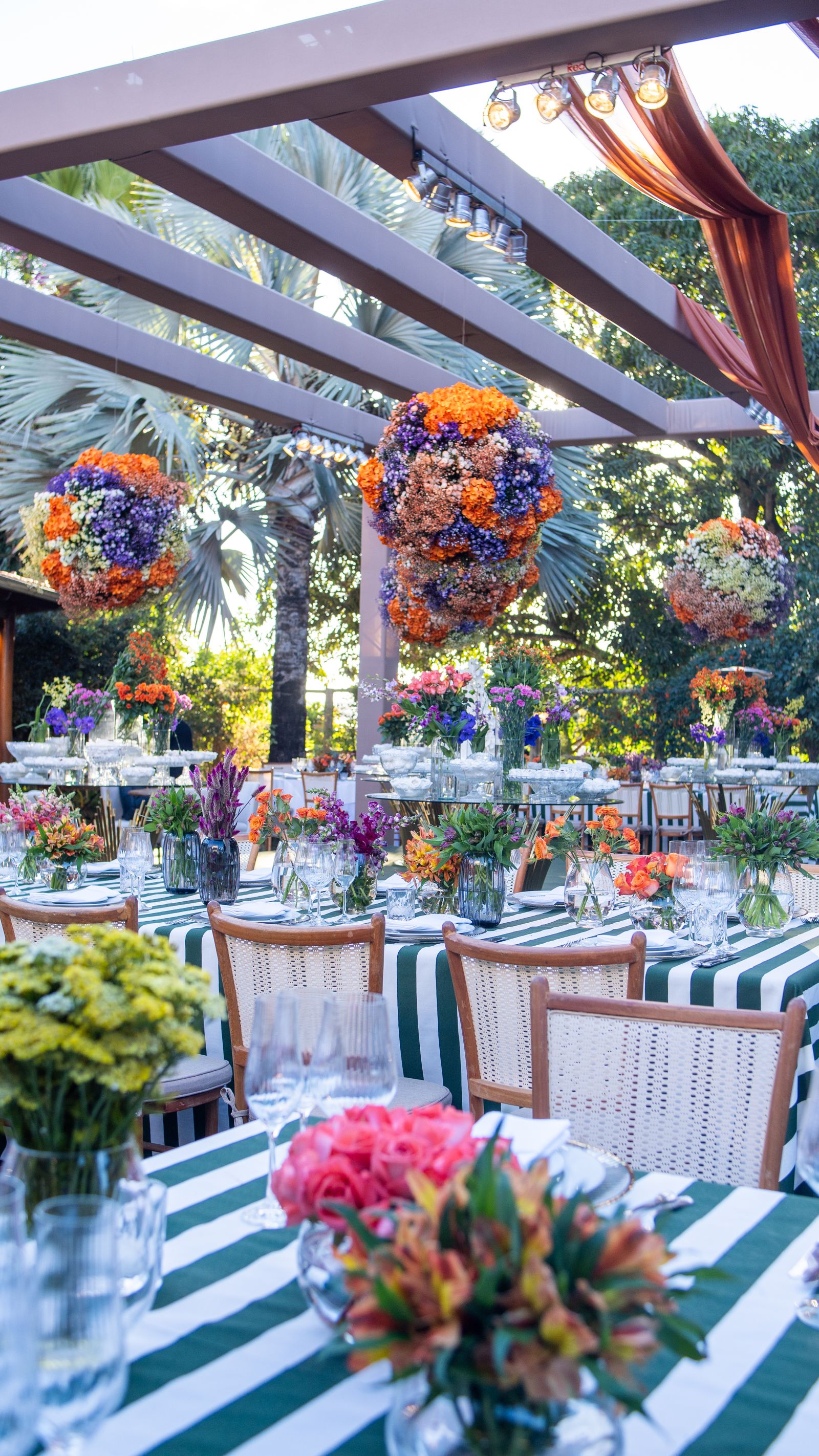 Gedekte tafels met gestreepte kleden en veel bloemen